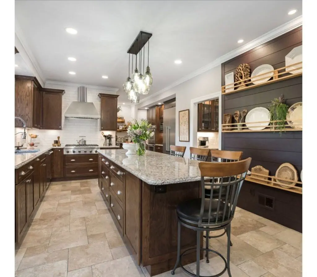 Traditional kitchen with wood cabinets, granite island, and chandelier lighting.
