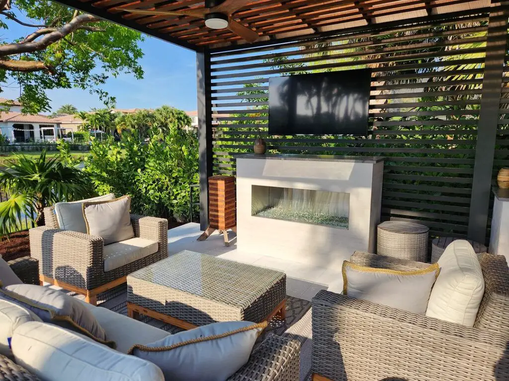Pergola covered patio with wicker furniture fireplace and TV