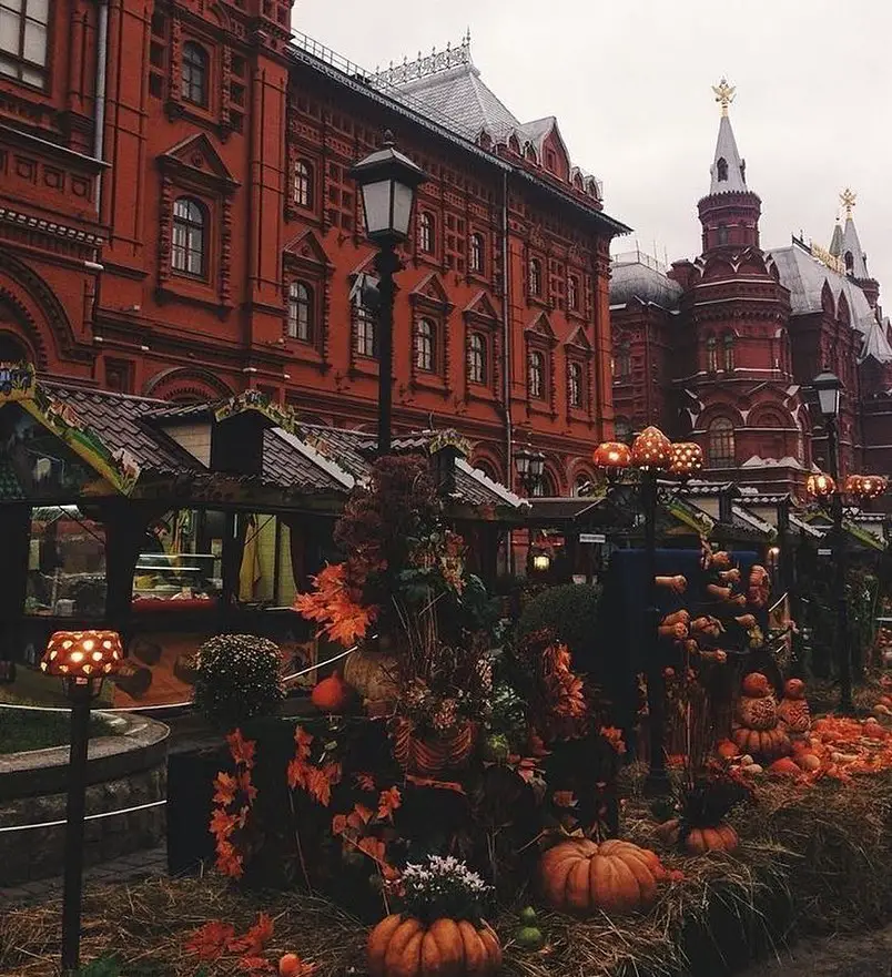 Autumn market with pumpkins before historic red building