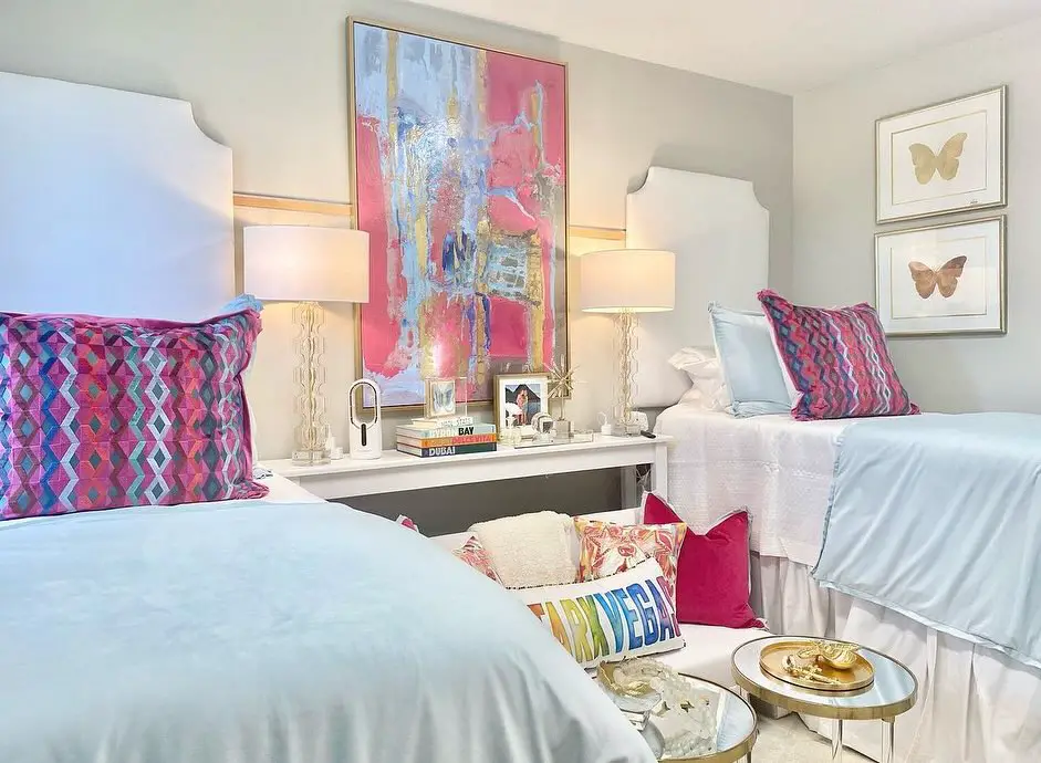Colorful bedding, artwork, table lamps in stylish dorm room.