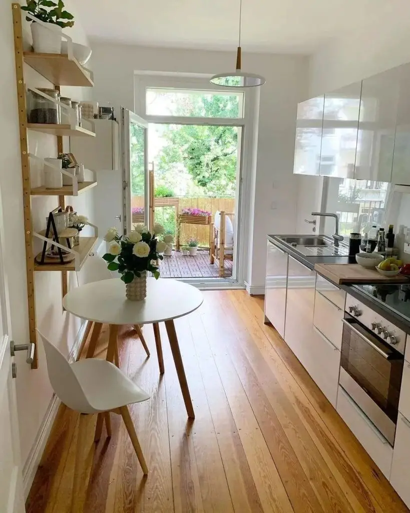 Bright kitchen with white cabinets and door to balcony garden