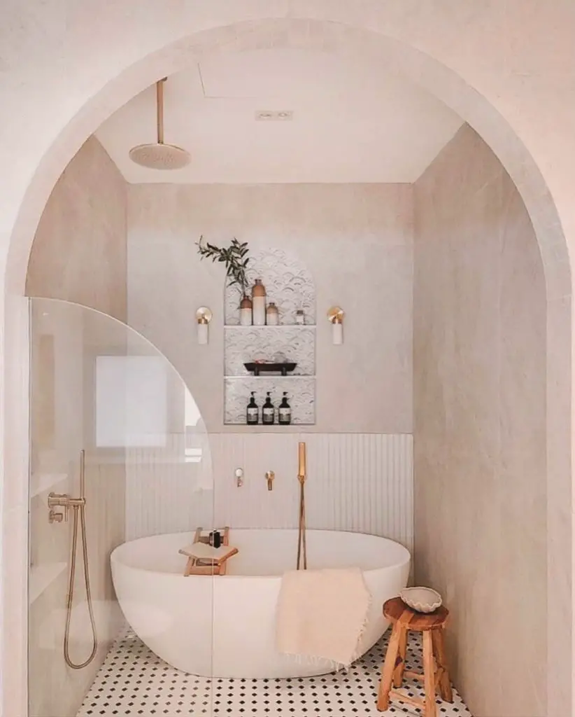 Arched bathroom with freestanding tub and neutral decor
