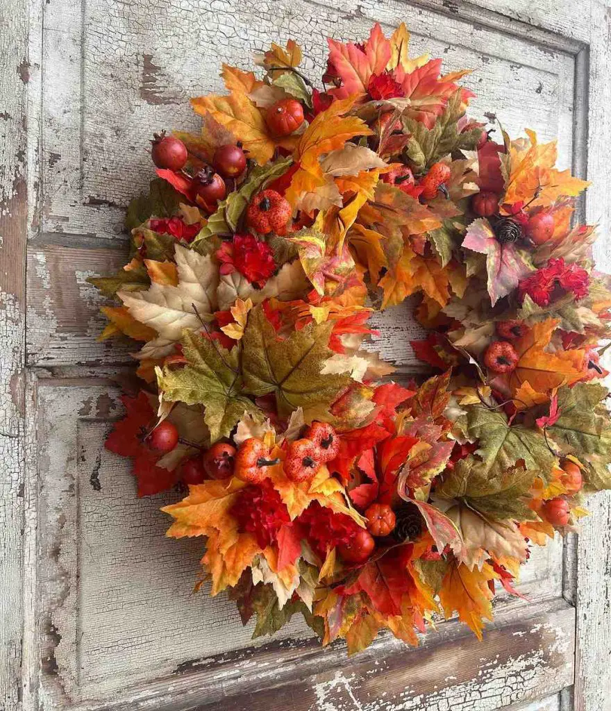 Colorful fall wreath with leaves pumpkins and berries