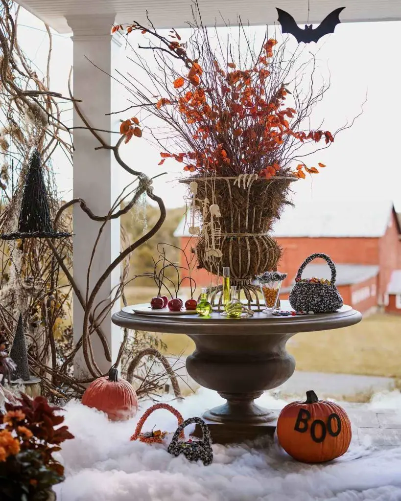 Halloween porch display with autumn leaves potions and pumpkins