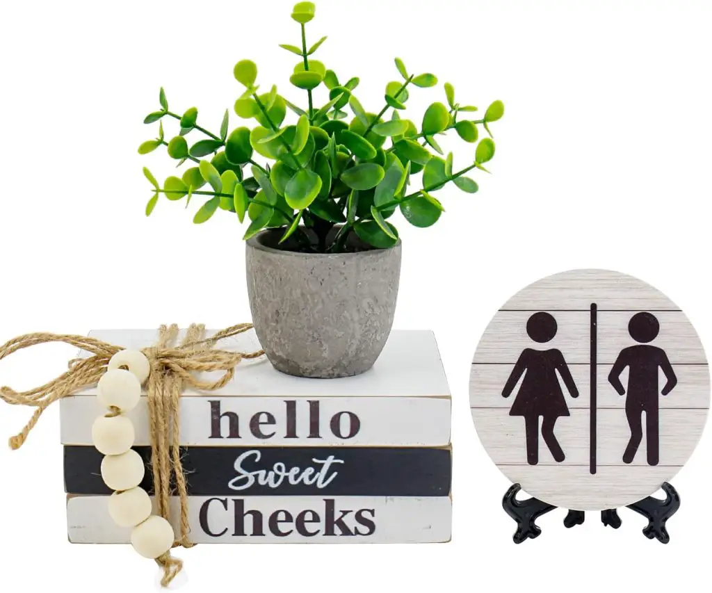 A gray potted plant sits on top of stacked wooden blocks decorated with beads and twine.