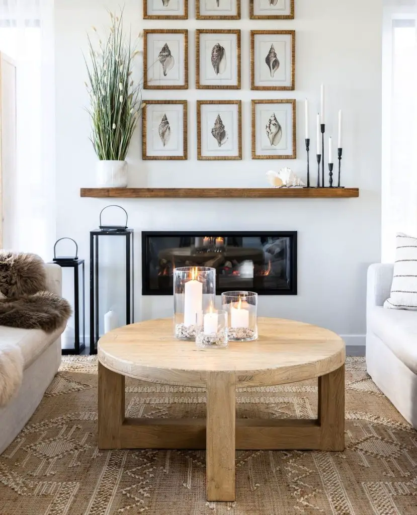 Coastal living room with round wooden coffee table and seashell wall art