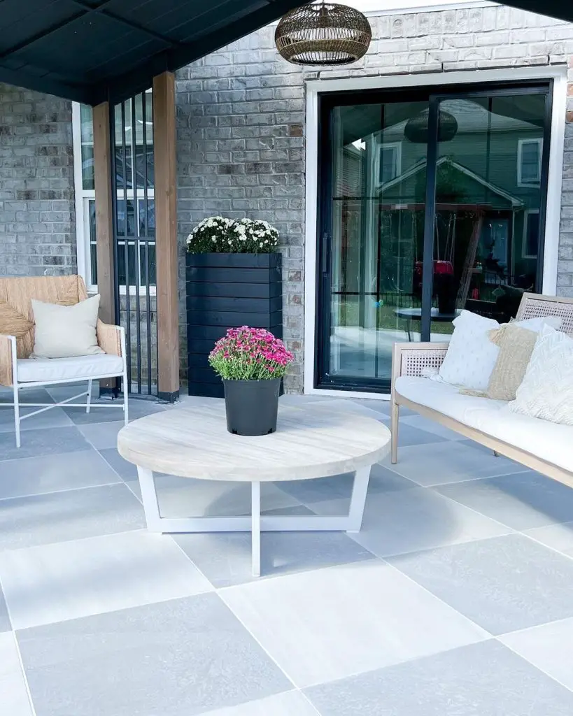 Outdoor patio with round coffee table and potted pink flowers