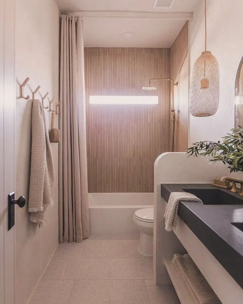 Blush bathroom with wood accents and woven light fixture