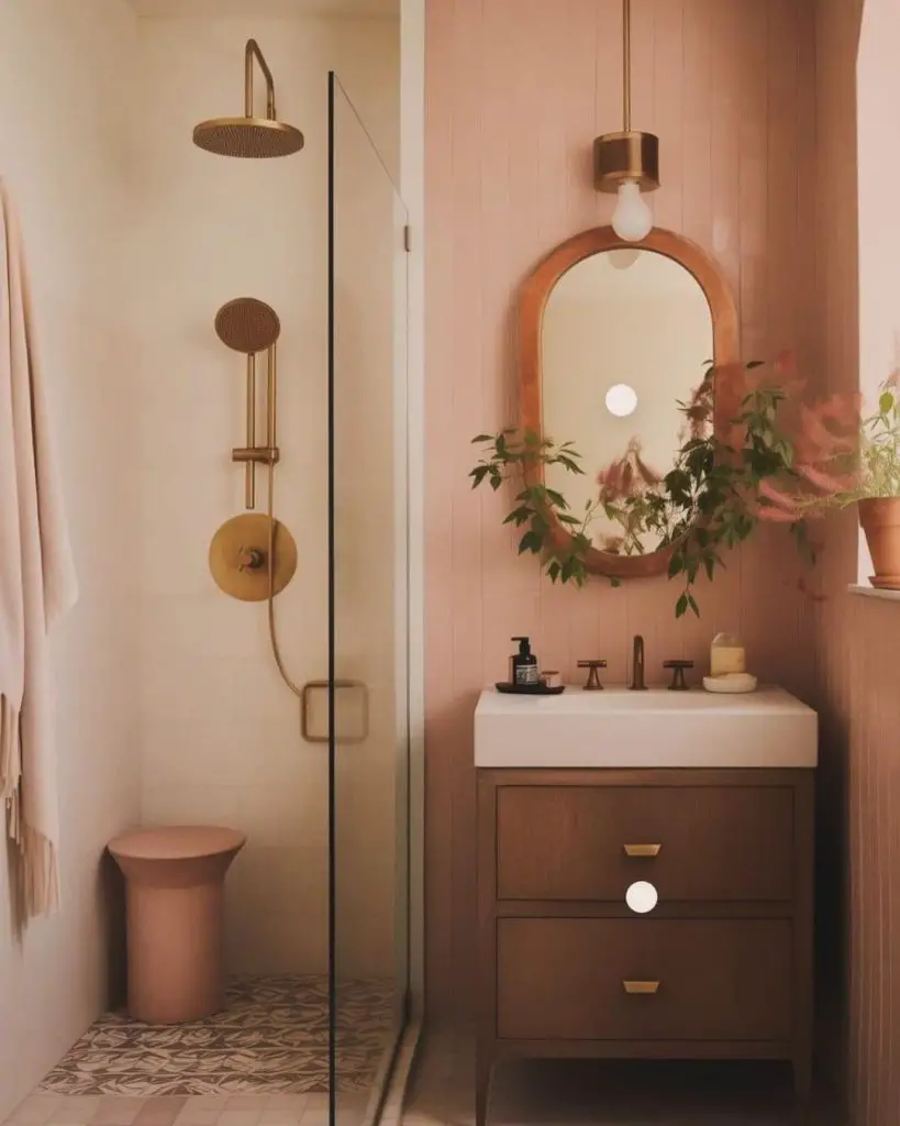 Pink bathroom with gold fixtures and plants