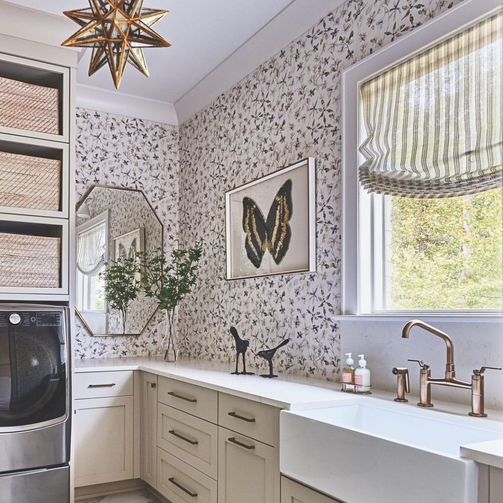 Laundry room with butterfly wallpaper and gold accents.