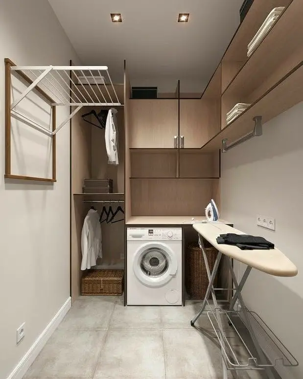 Compact laundry room with wood cabinets folding clothesline and built-in ironing board