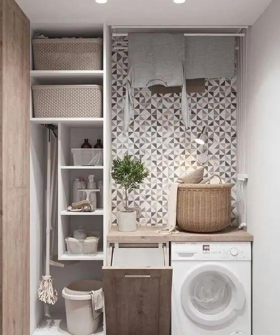 Compact laundry nook with geometric wallpaper, built-in storage, and integrated washing machine.