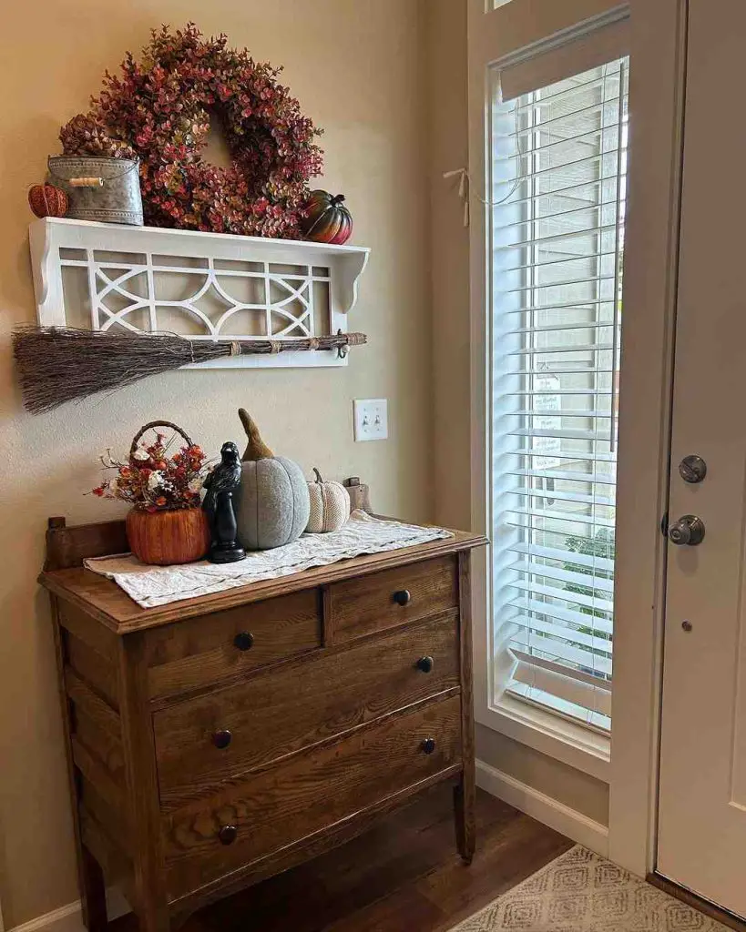 Fall-decorated entryway with wreath dresser and pumpkins
