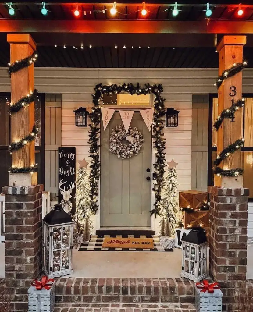 Festive farmhouse porch with lights wreath and trees