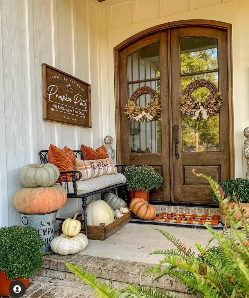 Fall decorated porch with pumpkins wreaths and cozy seating