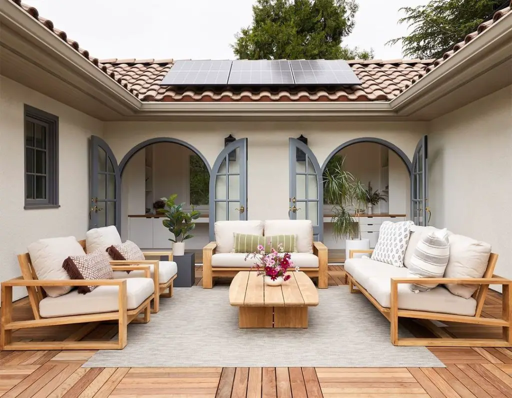 Courtyard with teak furniture solar panels and arched French doors