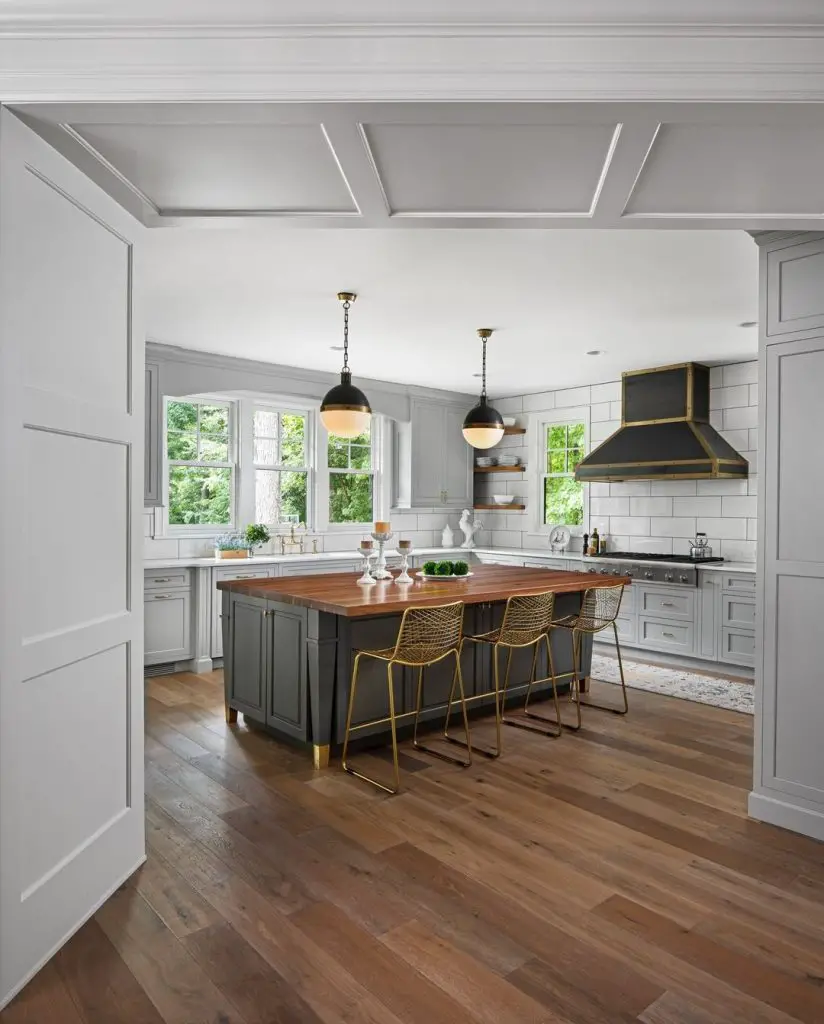 Bright kitchen with white cabinets dark island and gold accents