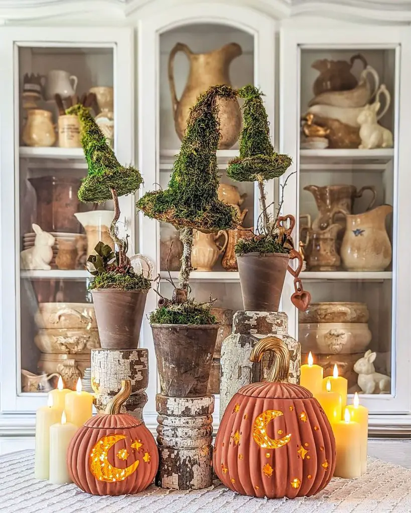 Hutch with mossy witch hat topiaries glowing pumpkins and candles
