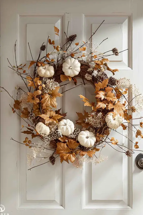 Autumn wreath with white pumpkins and golden leaves