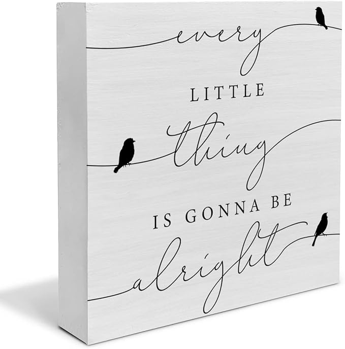A white, rectangular wooden block with cursive text that reads, “every little thing is gonna be alright.”
