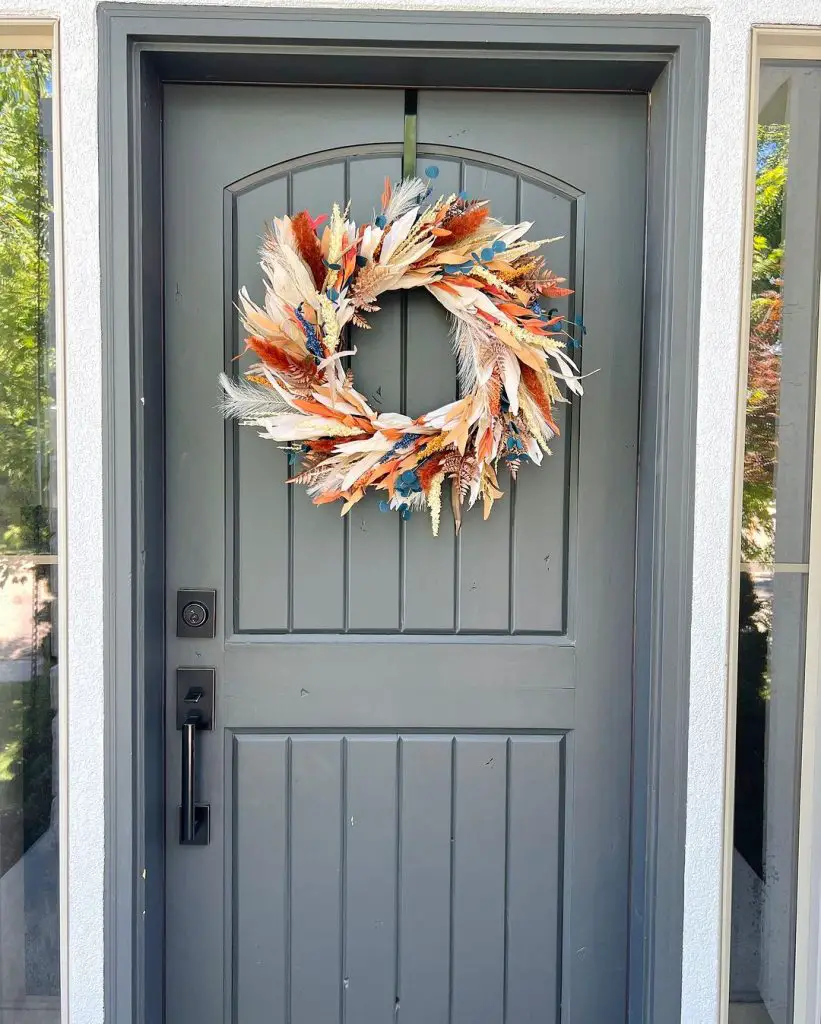 Colorful feather wreath on gray front door