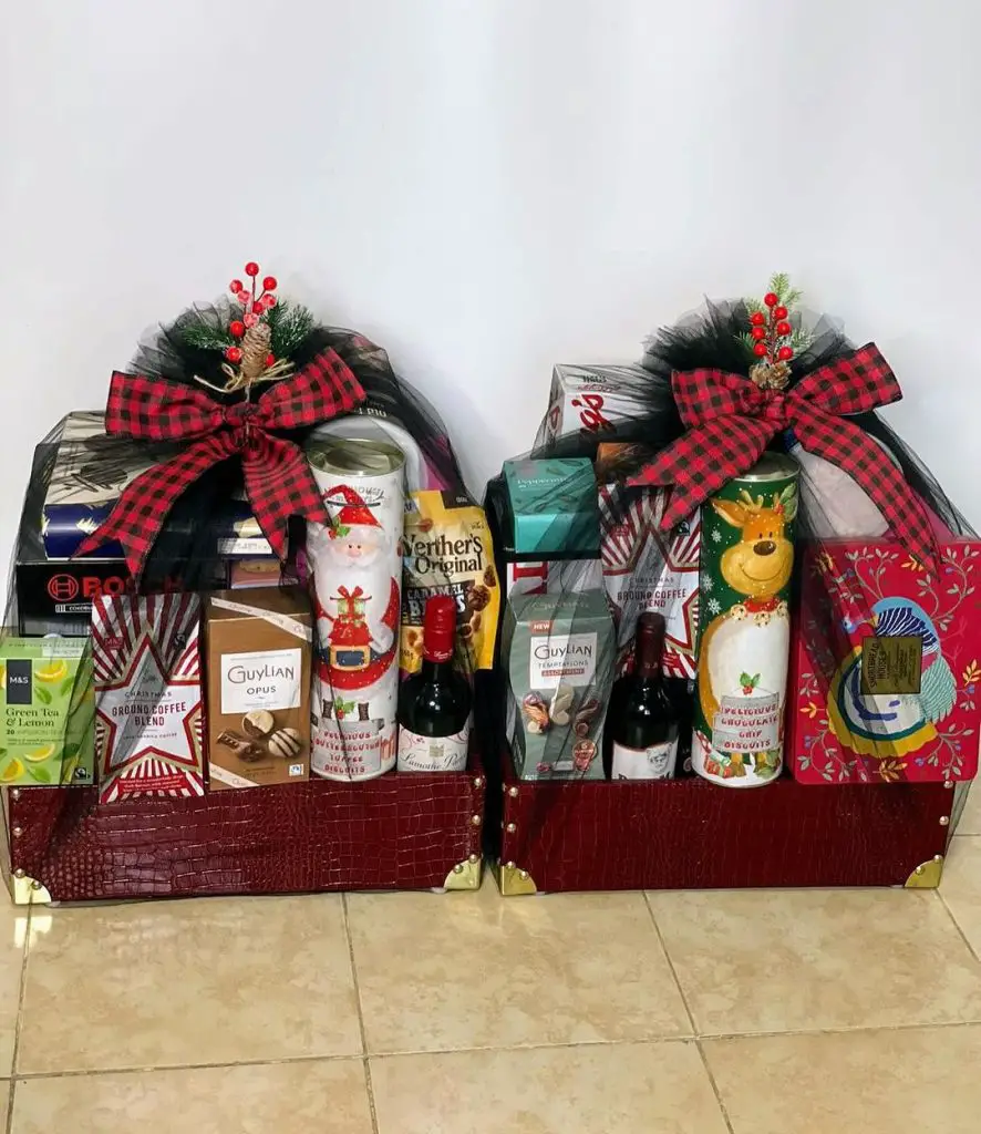 Two Christmas gift baskets with plaid bows filled with treats