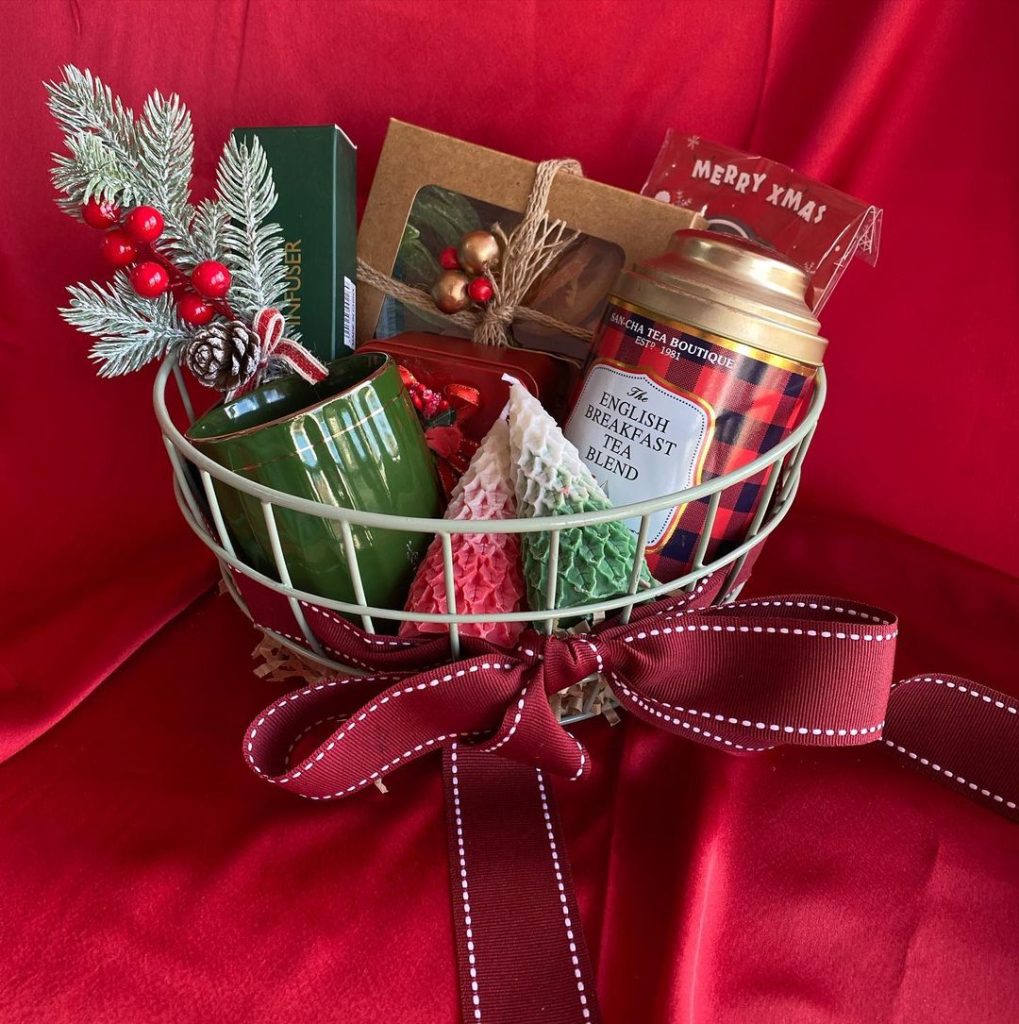 Christmas gift basket with tea, mug, and festive treats.