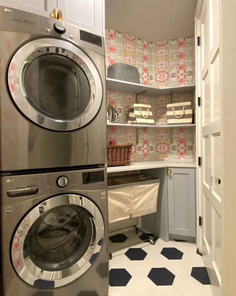 Floral wallpapered laundry closet with stacked machines and geometric flooring