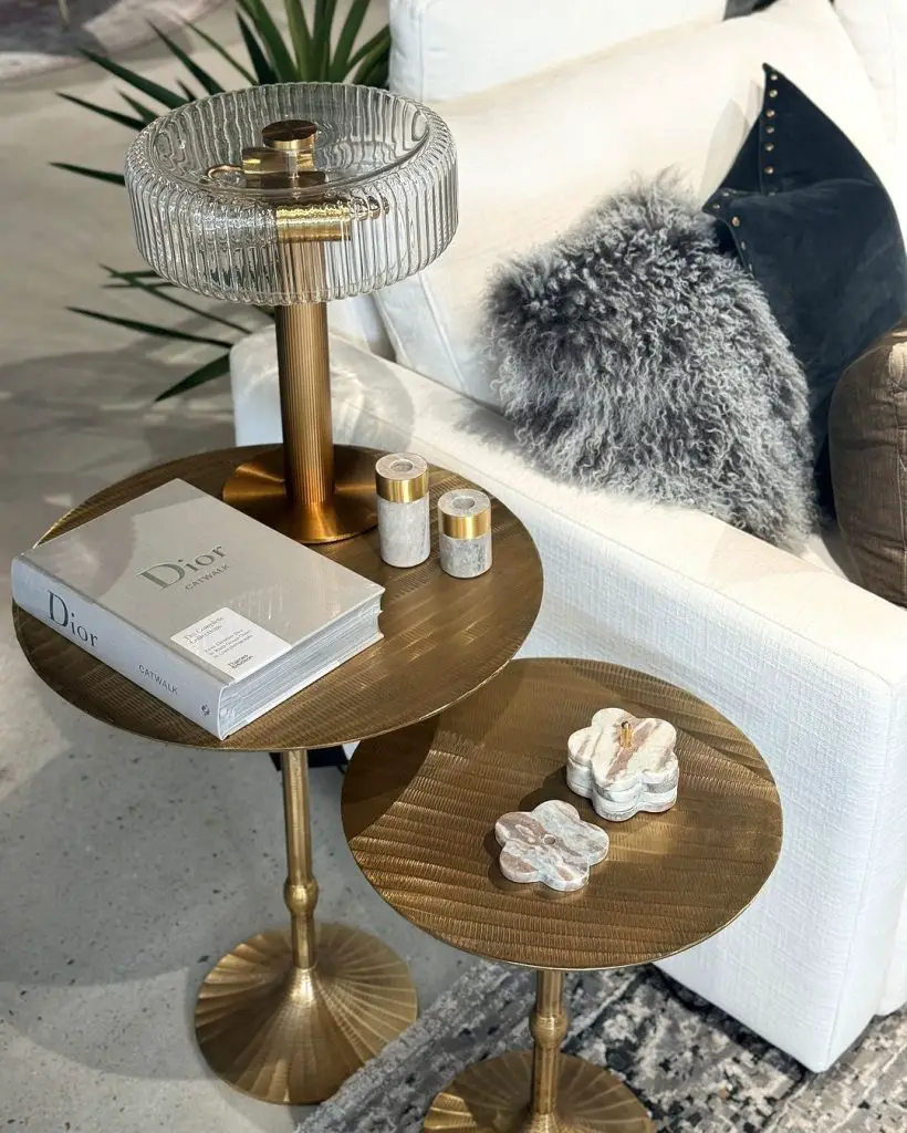 Luxurious side tables with gold accents, designer lamp, and decorative objects