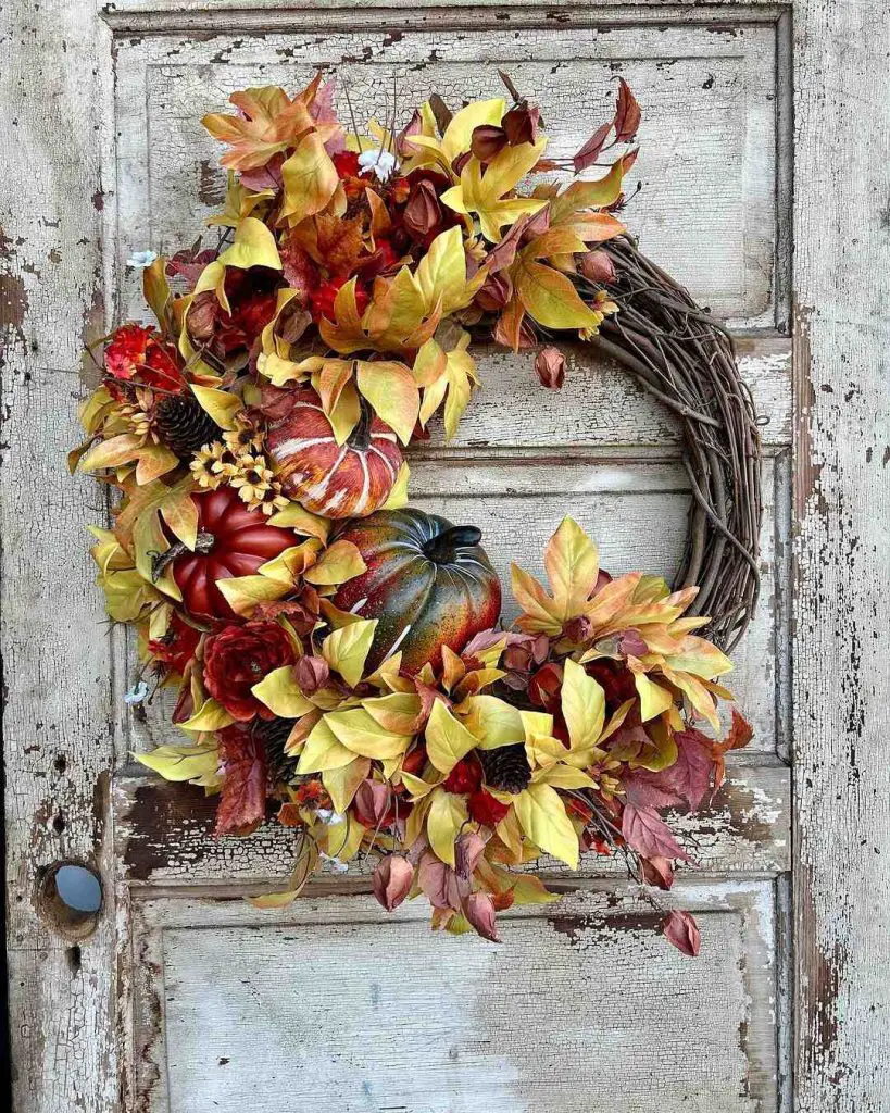 Colorful fall wreath with yellow leaves and pumpkins