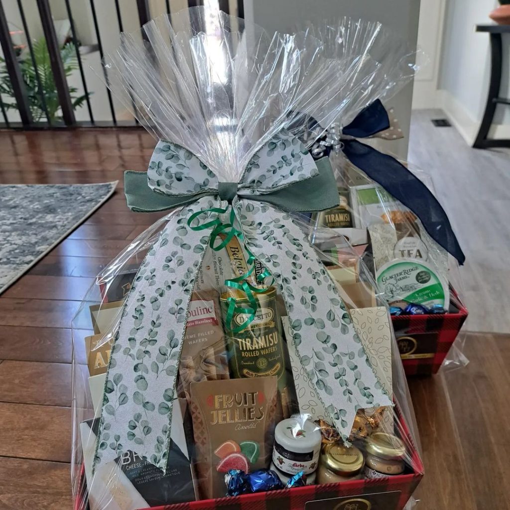 Holiday gift basket with gourmet snacks and tea wrapped in cellophane