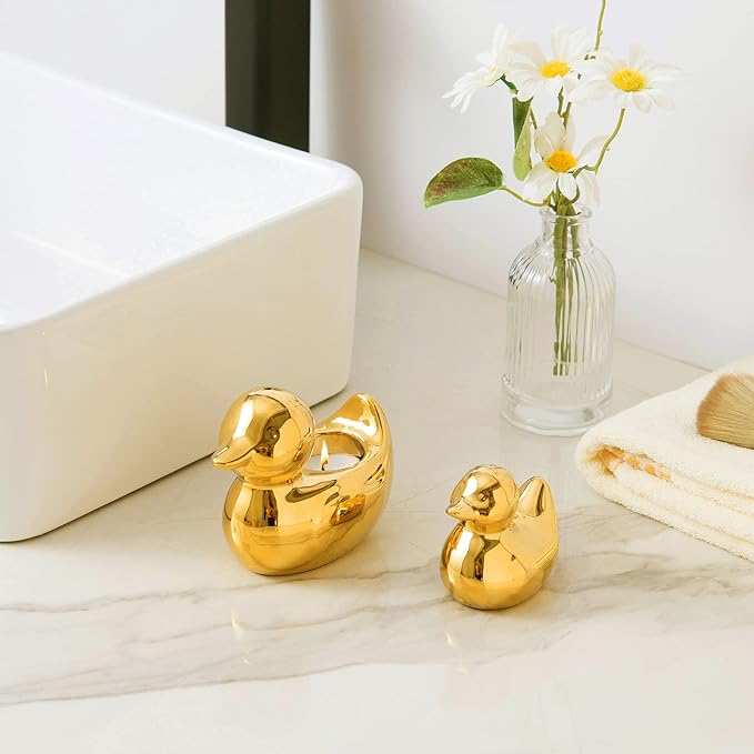 A bathroom counter features two golden duck ornaments, one larger than the other.