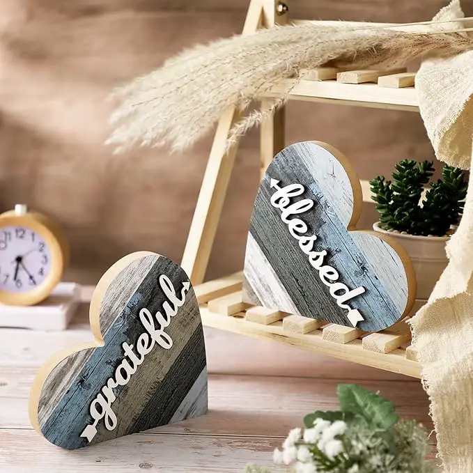 Two wooden heart-shaped signs that read "grateful" and "blessed" are displayed on a wooden shelf.