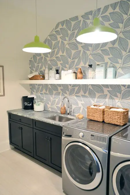 Laundry room with leaf wallpaper dark cabinets and green pendant lights