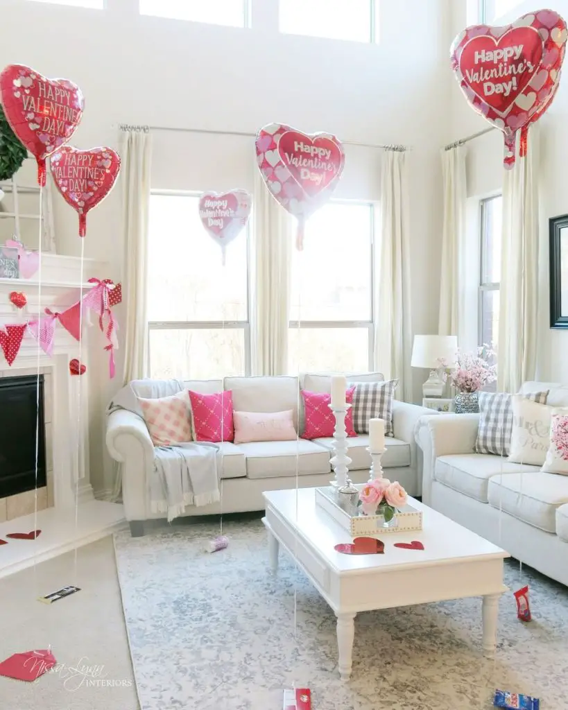 Living room decorated with Valentine's Day balloons, pink pillows, and heart-themed decor.