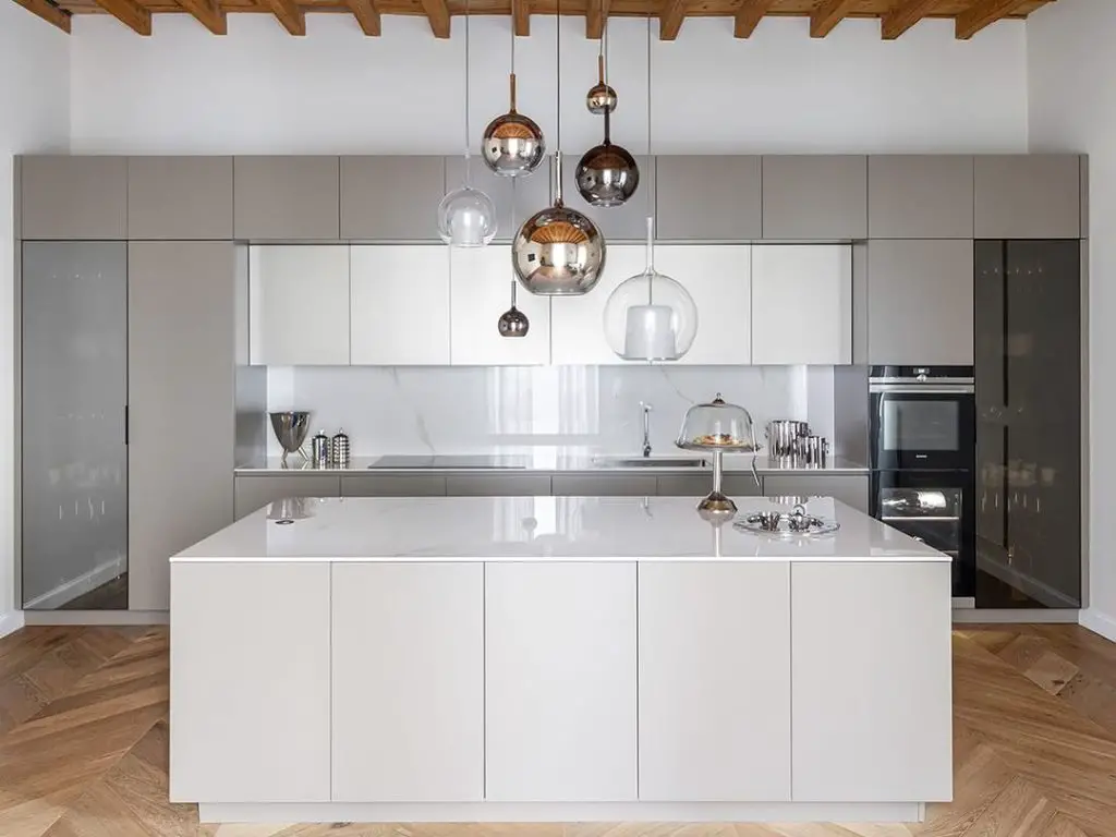 Modern white kitchen with wooden ceiling beams and hanging globe lights