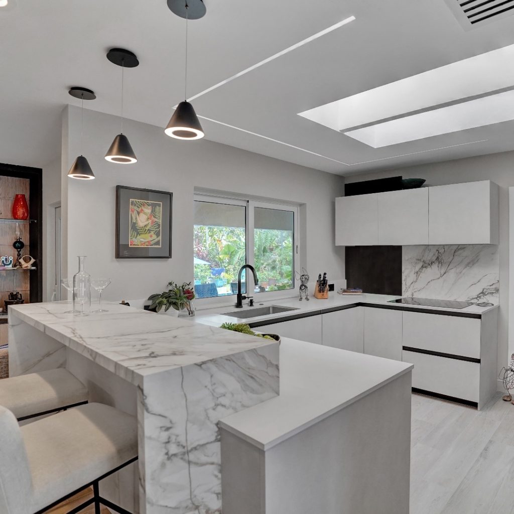 Bright white kitchen with marble countertops and skylight