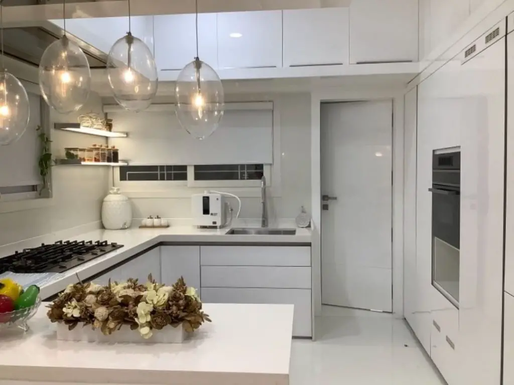 Bright compact kitchen with globe lights and white cabinetry