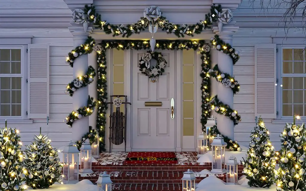 Snow-dusted porch with lit garlands and white decorations