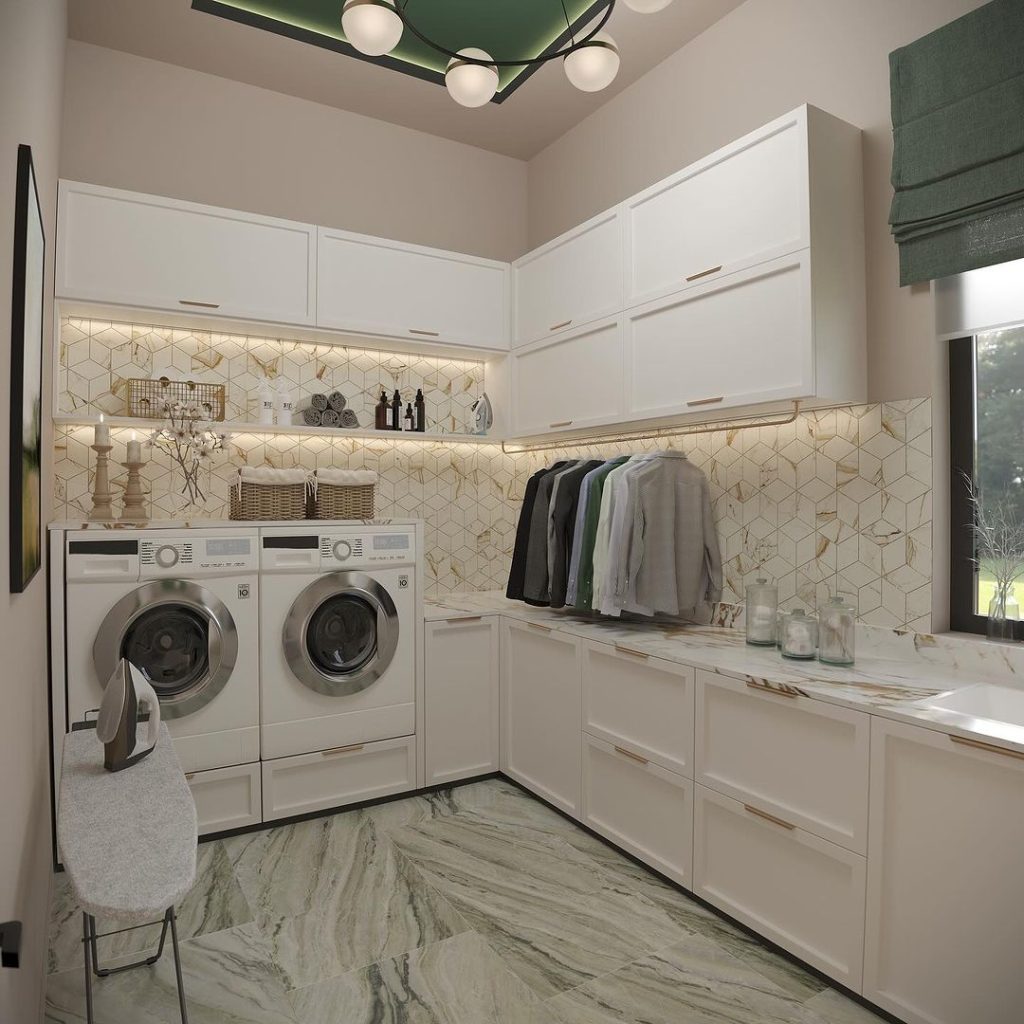 Elegant white laundry room with gold geometric backsplash and modern lighting