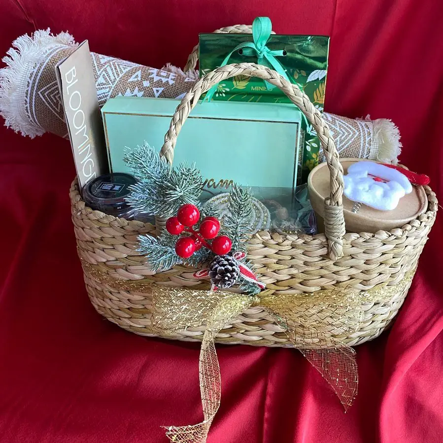 Wicker basket filled with mint green gifts and Christmas decorations.