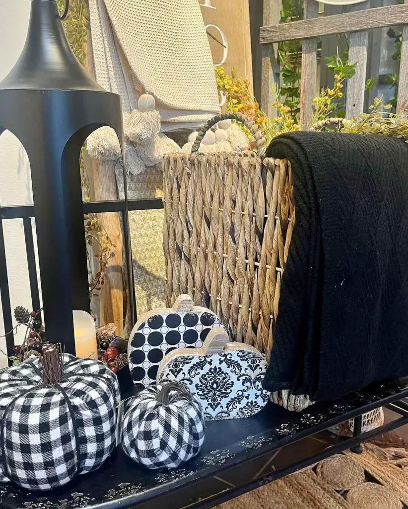 Outdoor nook with buffalo check pumpkins and black lantern