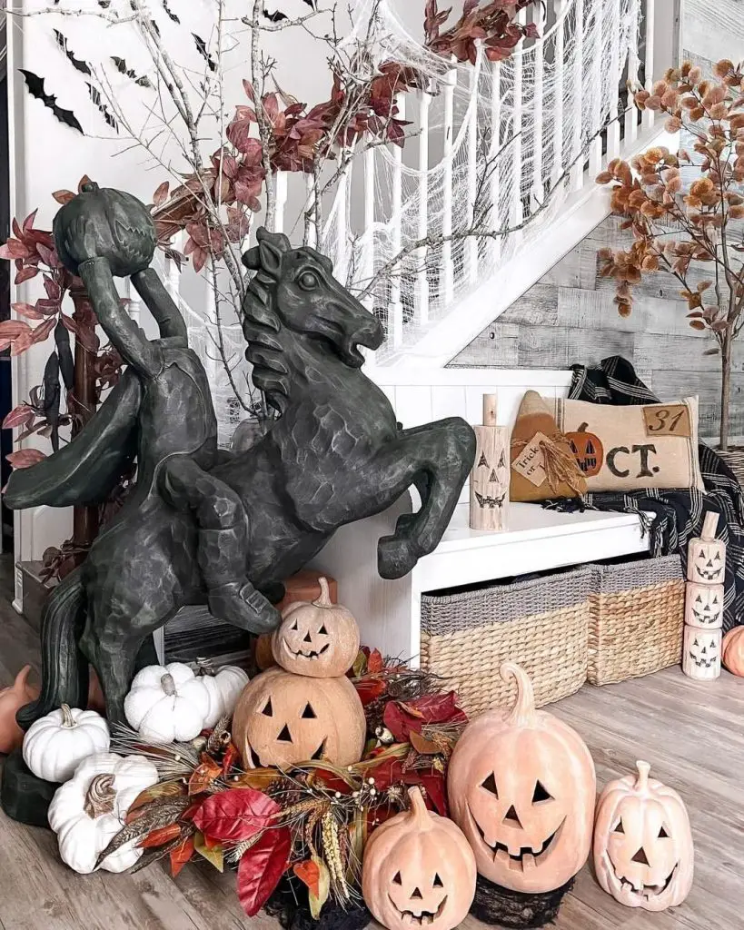Halloween decor featuring headless horseman statue pumpkins and autumn foliage