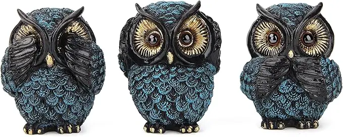 Three small ceramic owl figurines are arranged in a row.