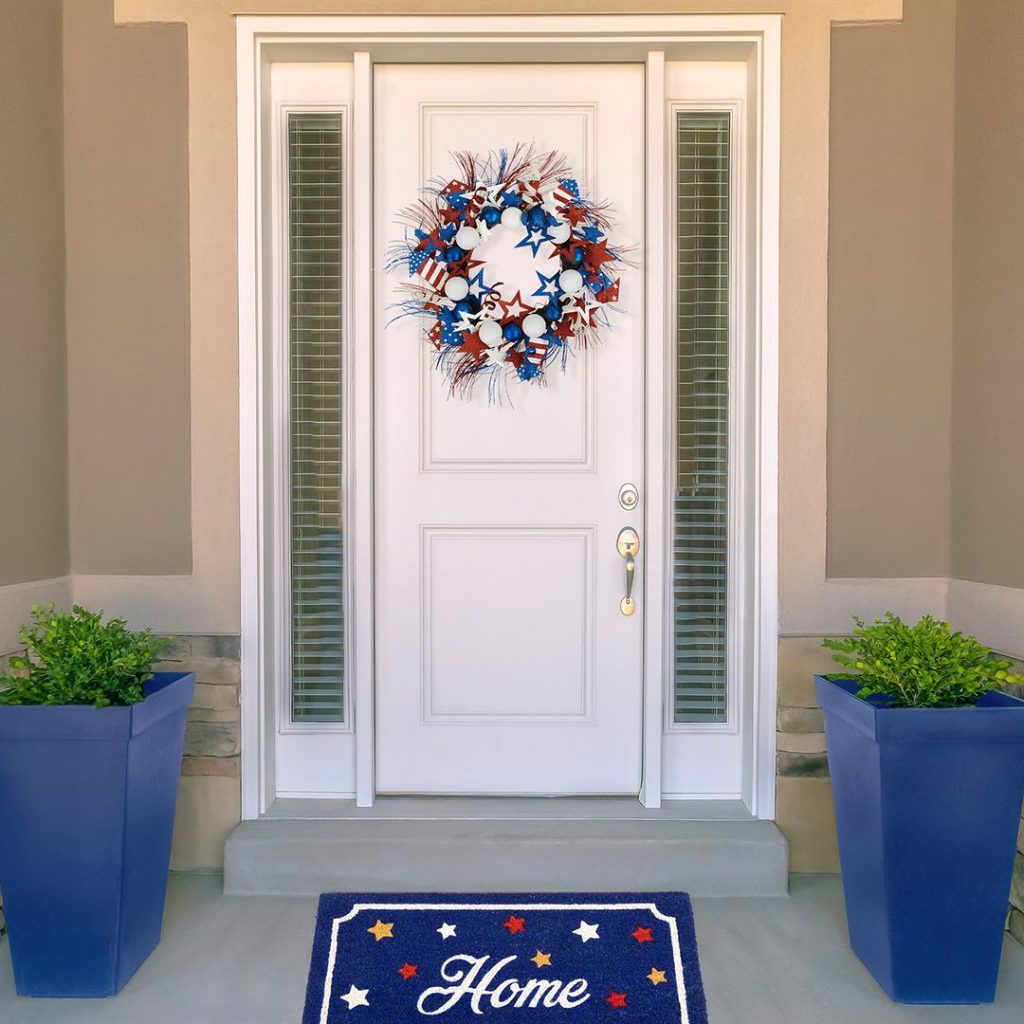 White door with patriotic wreath and blue welcome mat