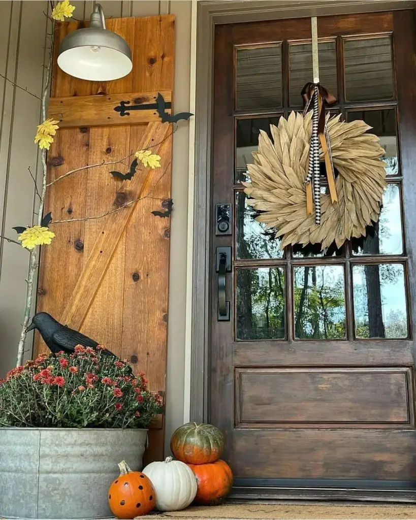 Rustic fall porch with corn husk wreath and pumpkins
