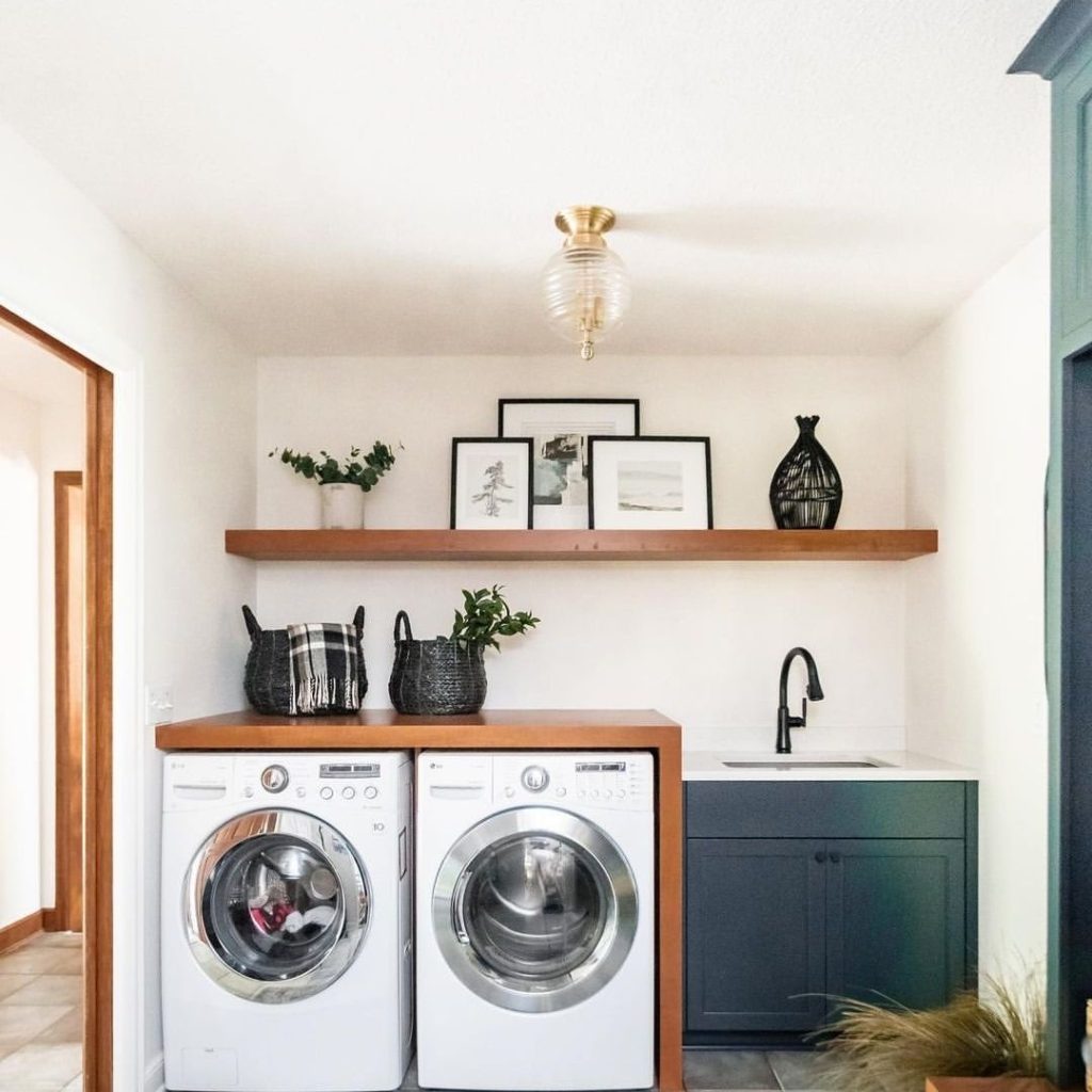 Compact laundry room with wooden shelves and decor