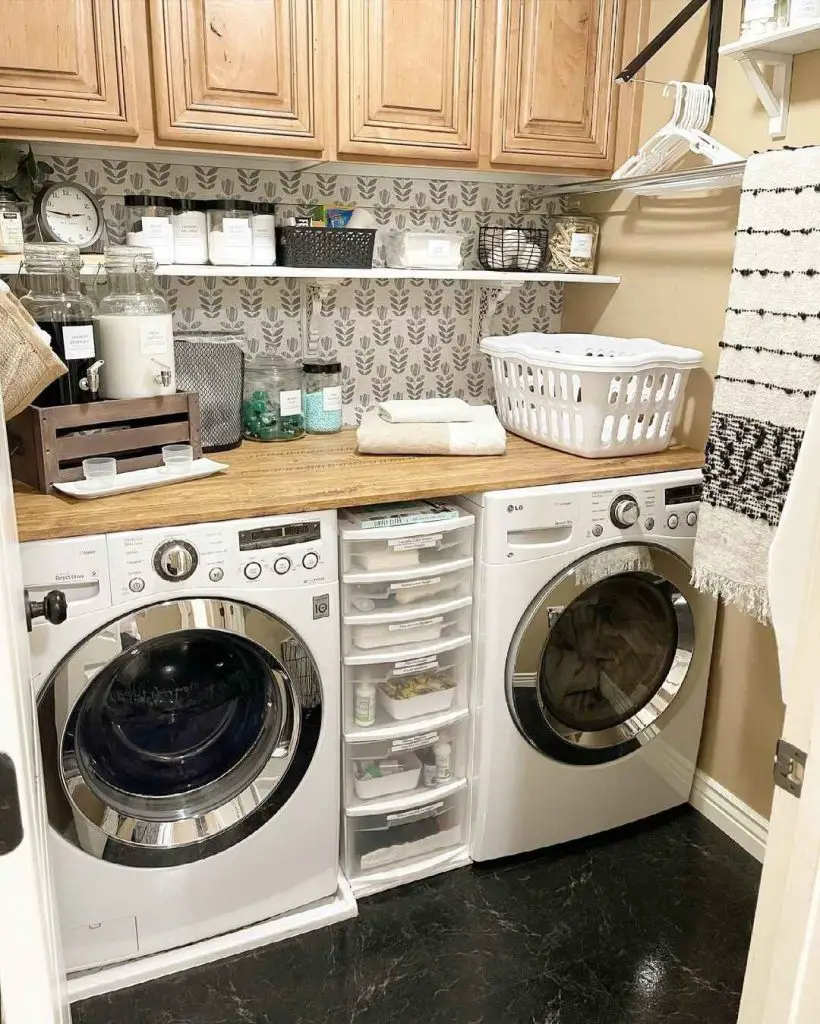 Compact laundry room with wooden cabinets and leaf-patterned wallpaper.