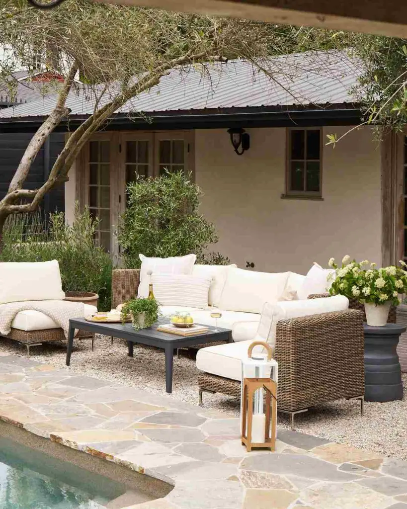 Cozy wicker patio set near cottage with pool edge visible