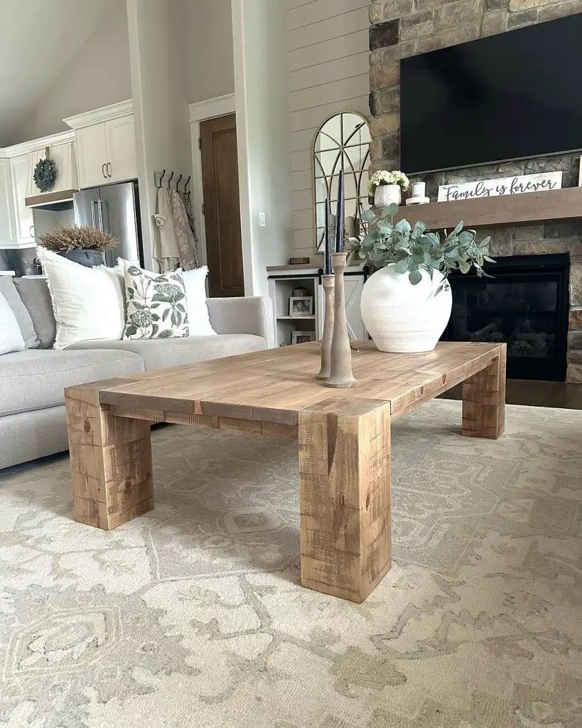 Living room with rustic wooden coffee table, stone fireplace, and modern farmhouse decor.